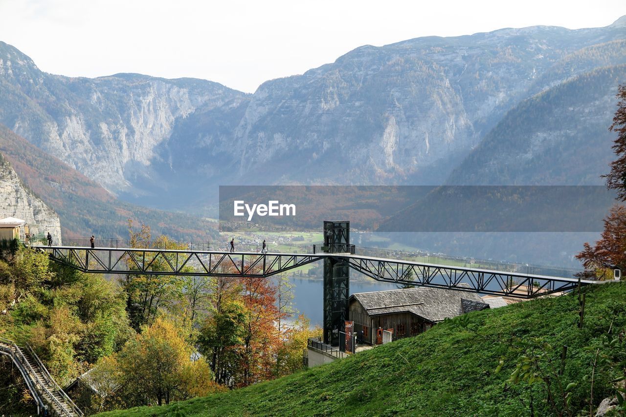 Bridge by mountains against sky