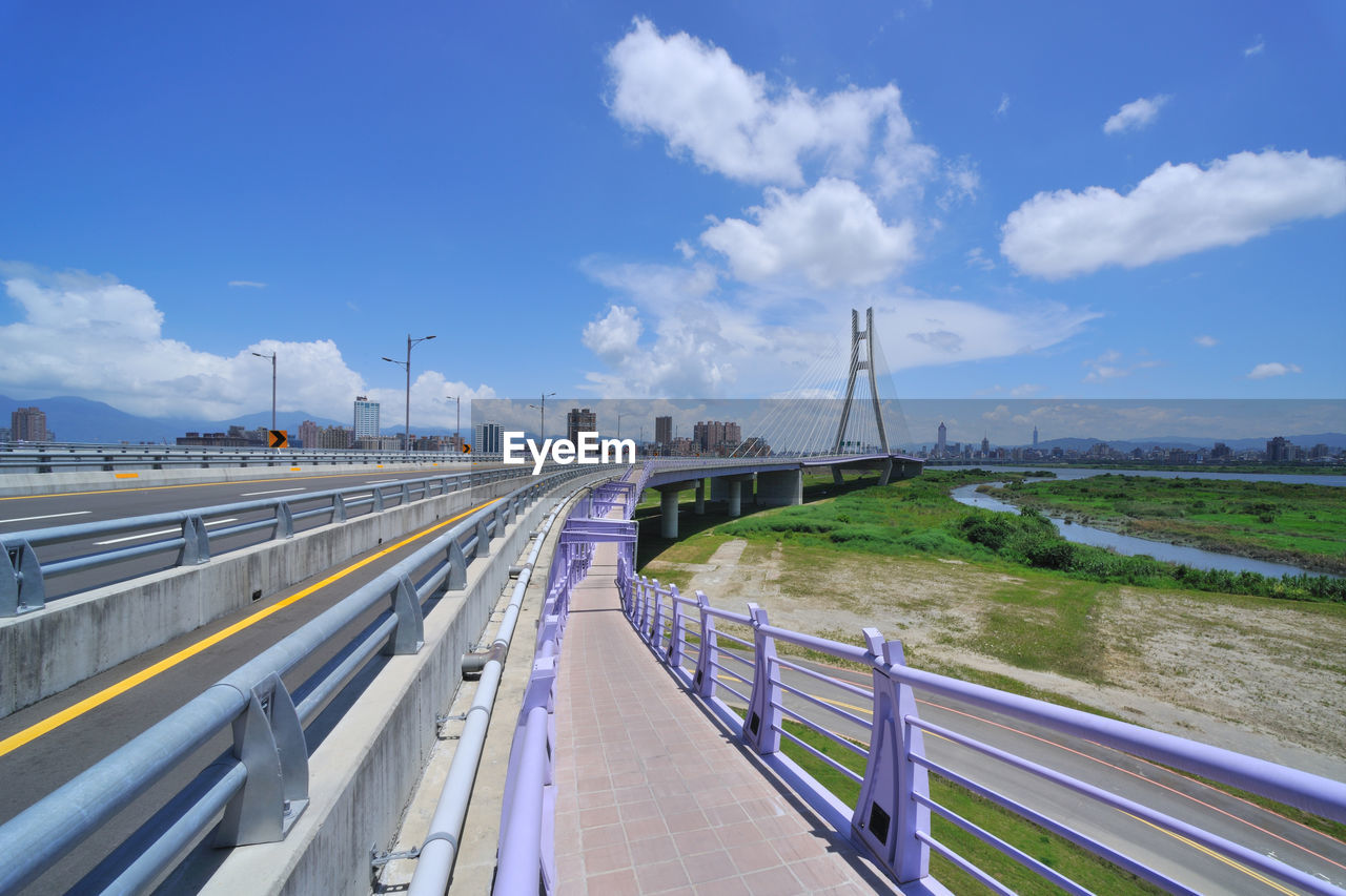 VIEW OF BRIDGE OVER ROAD AGAINST SKY