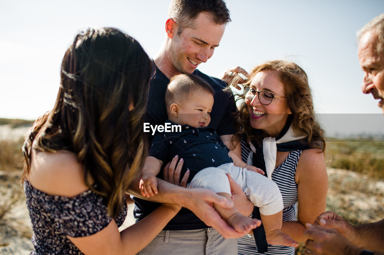 Family smiles as dad holds baby