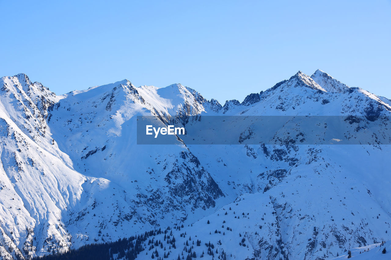 SNOWCAPPED MOUNTAINS AGAINST CLEAR BLUE SKY