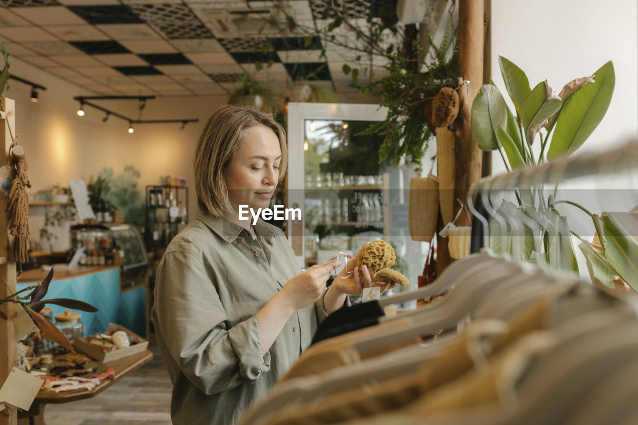 Blond customer reading label on organic loofah in store