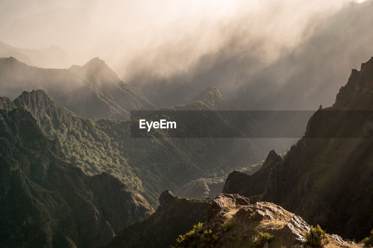 Scenic view of mountains against sky with fog