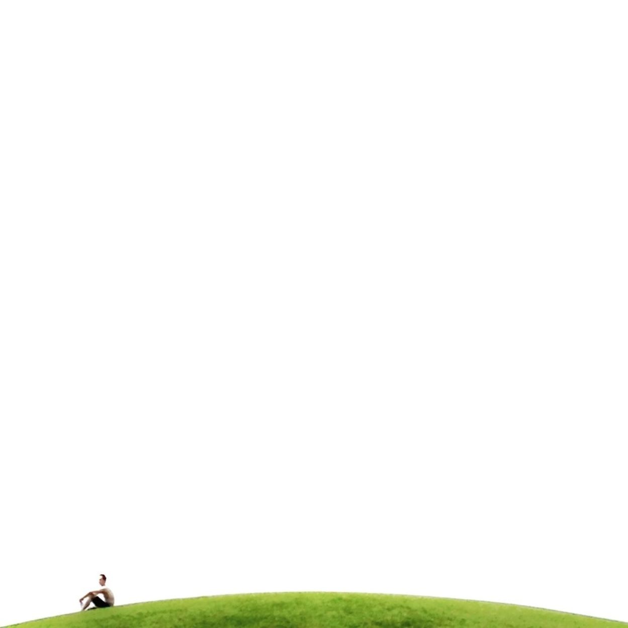 Man sitting on hill against clear sky