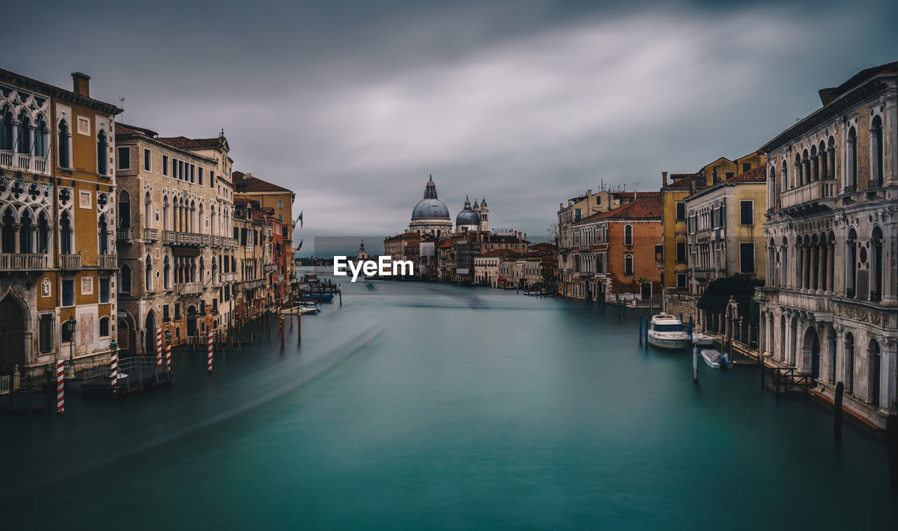 View of buildings in city against cloudy sky