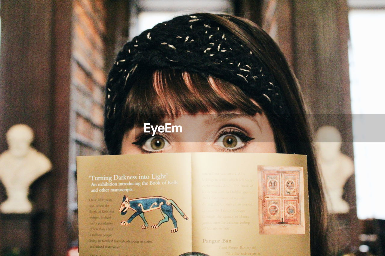 CLOSE-UP PORTRAIT OF WOMAN WITH BOOK