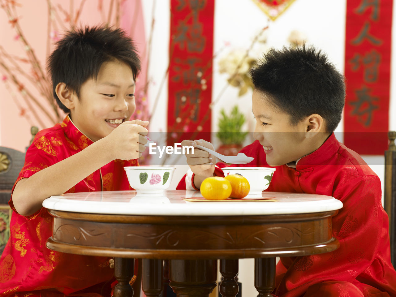 Boys having soup while sitting at table during festival