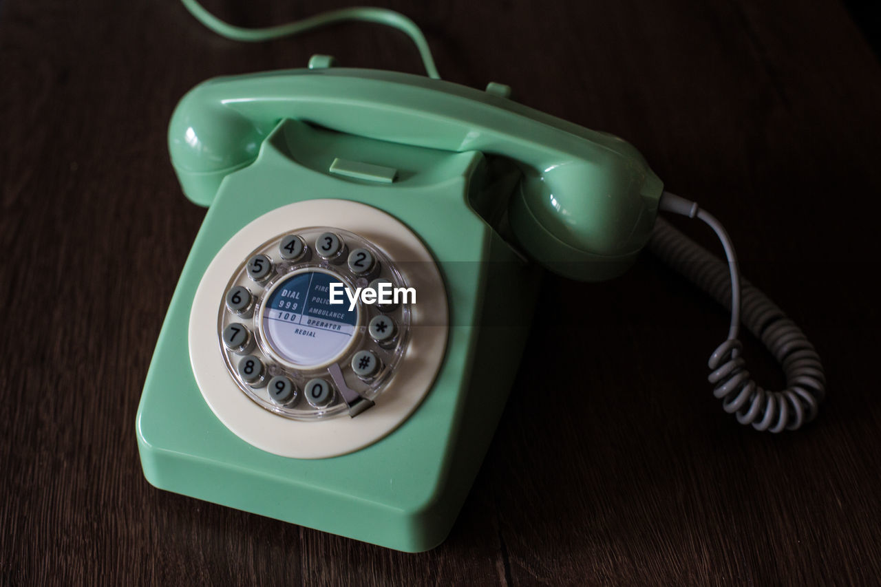 High angle view of rotary phone on wooden table