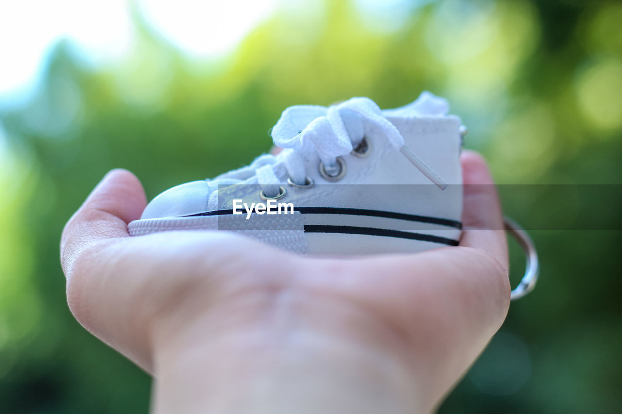 Close-up of hand holding a shoe miniature