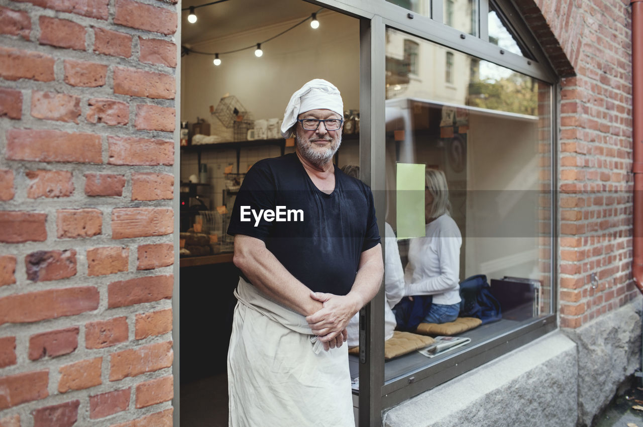 Portrait of senior male baker standing at bakery