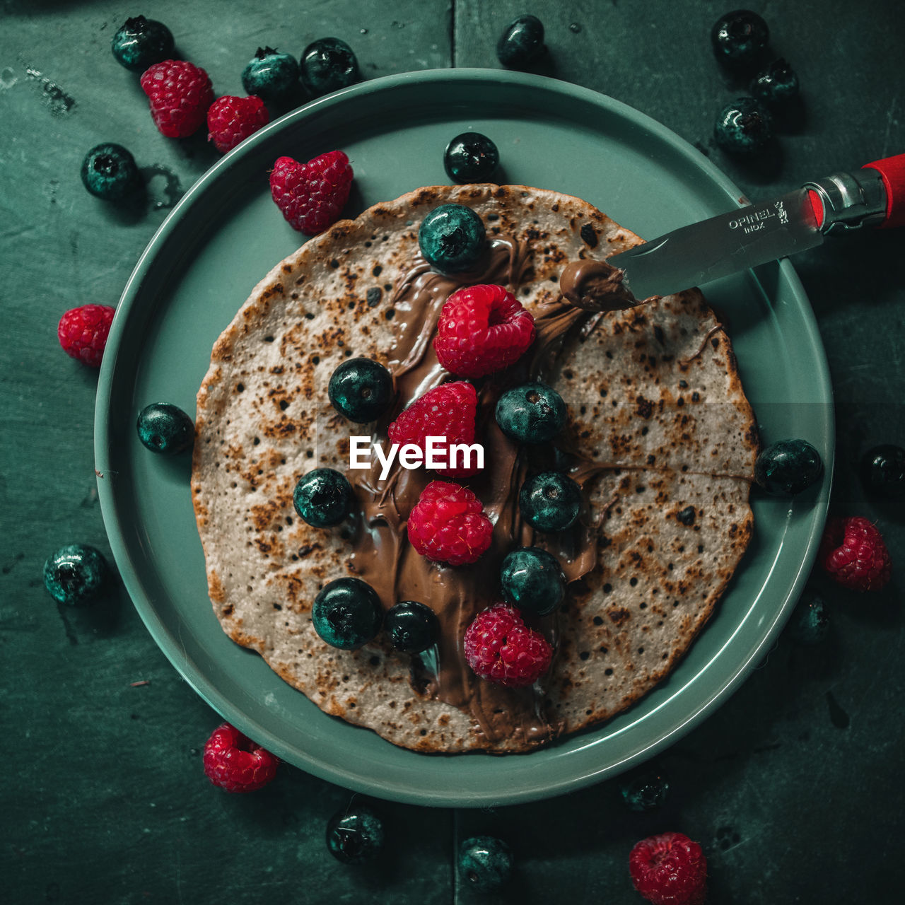 Close-up of pancake and berry fruits in plate