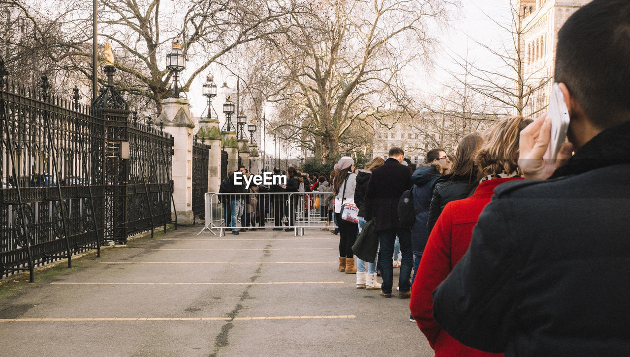 People standing in queue at parking lot