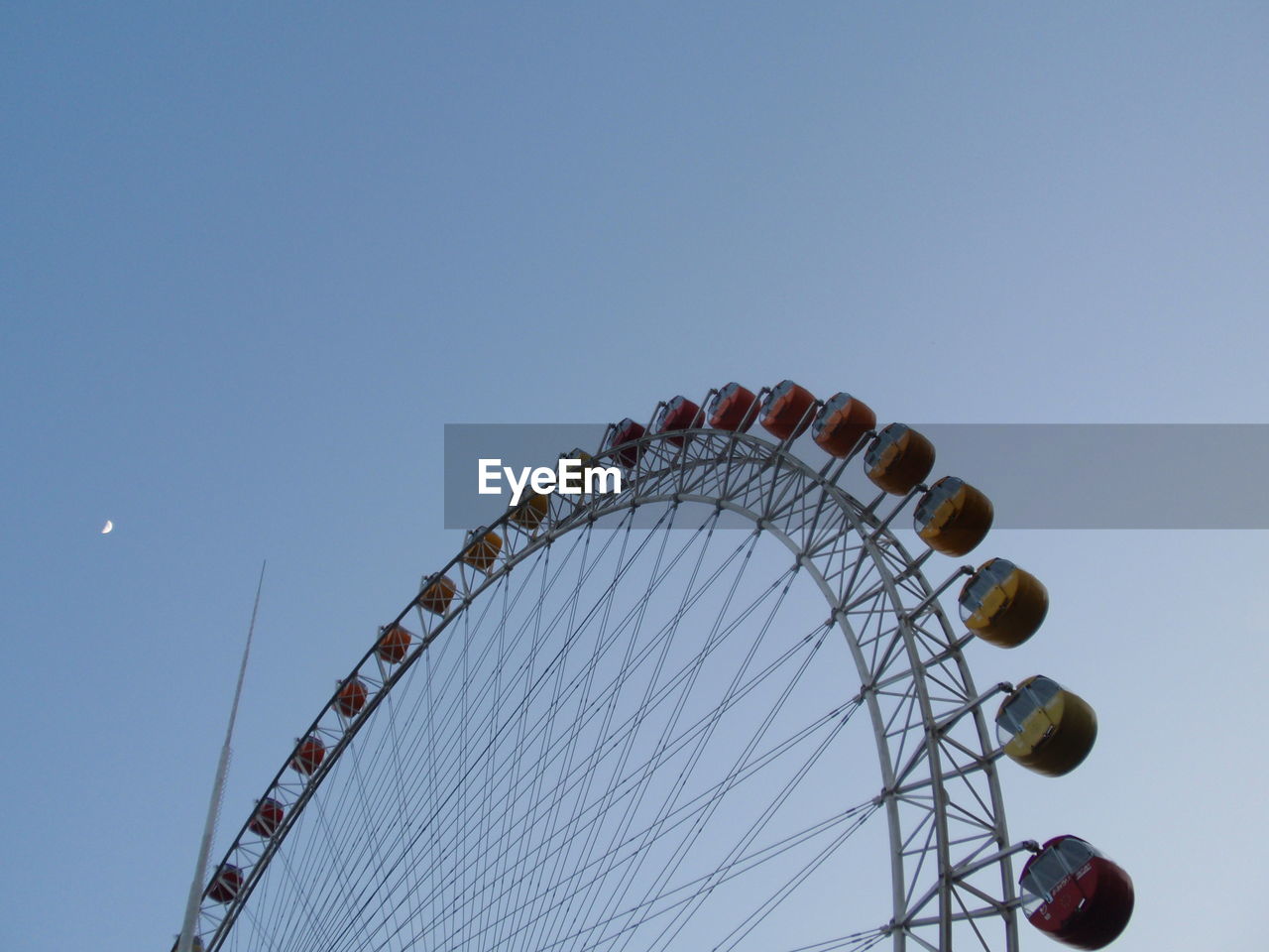 Low angle view of ferris wheel against blue sky 