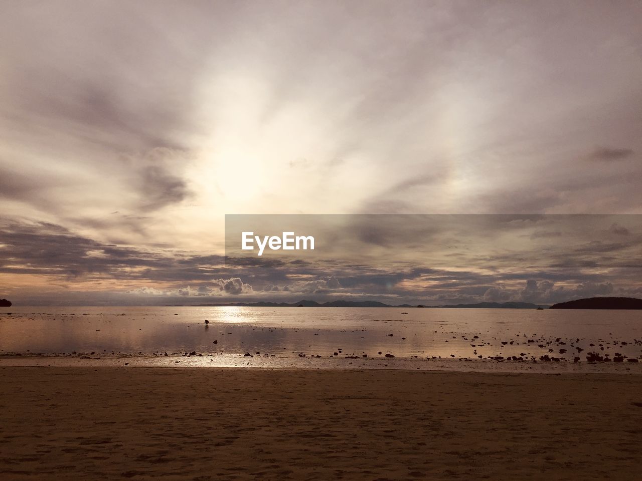 SCENIC VIEW OF BEACH AGAINST SKY AT SUNSET