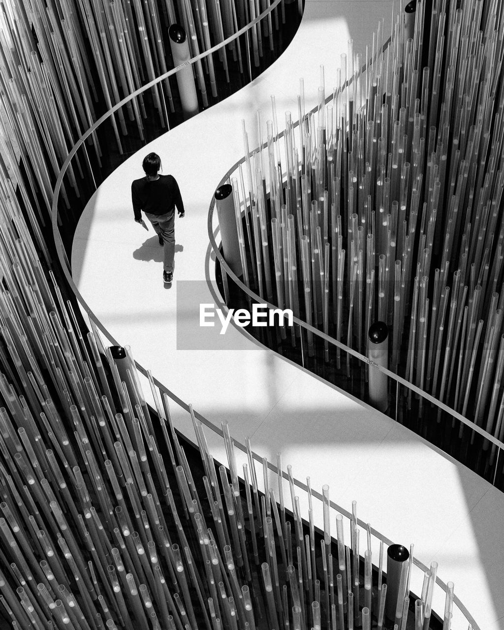 HIGH ANGLE VIEW OF MAN MOVING ON STAIRCASE IN CITY