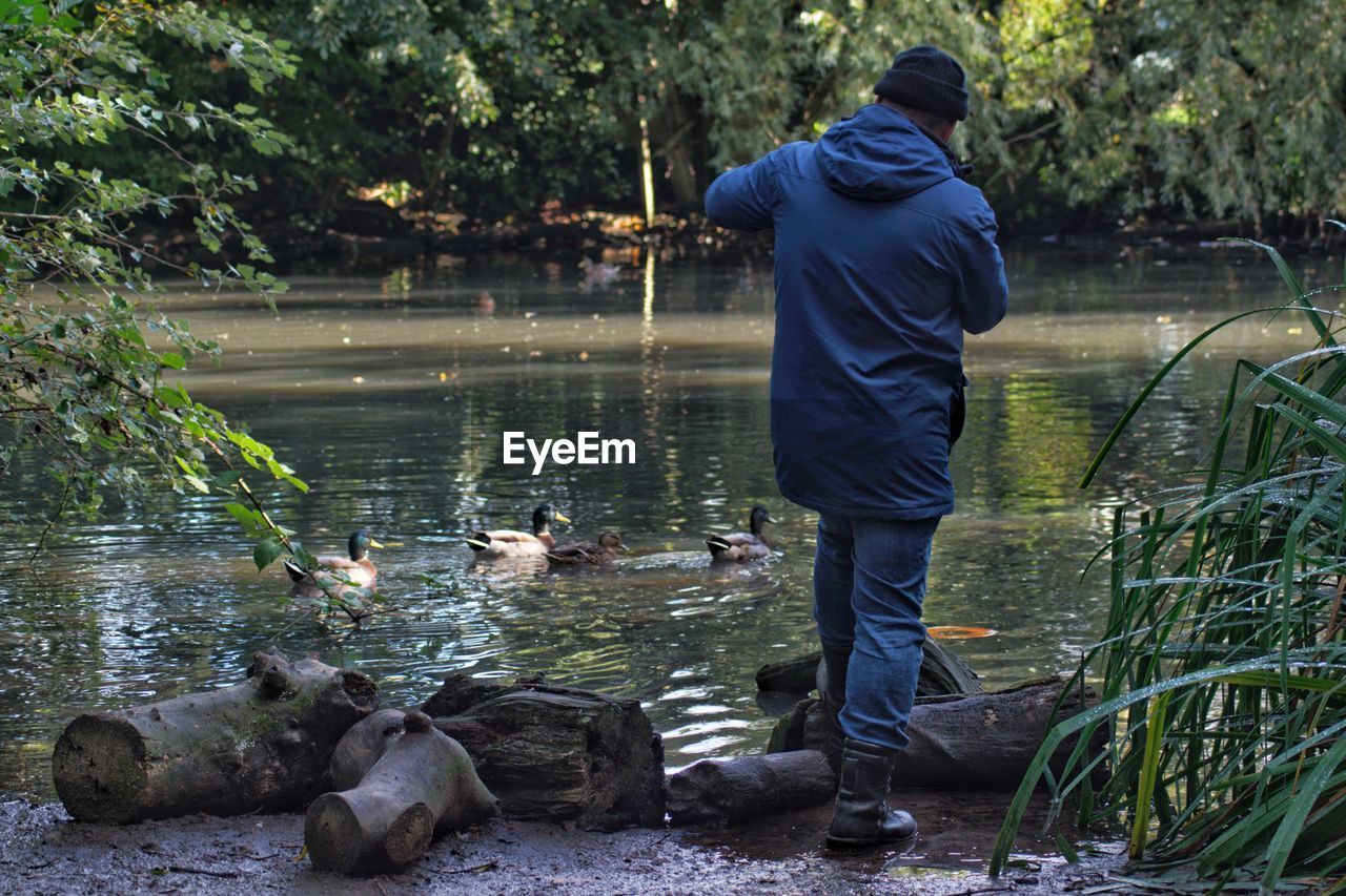 Man taking photos at the duck pond in the woods