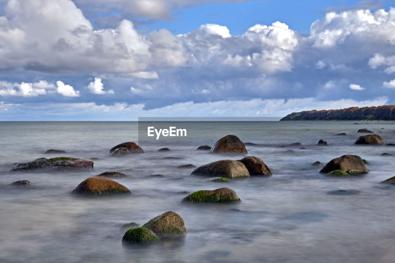 ROCKS ON SHORE AGAINST SKY