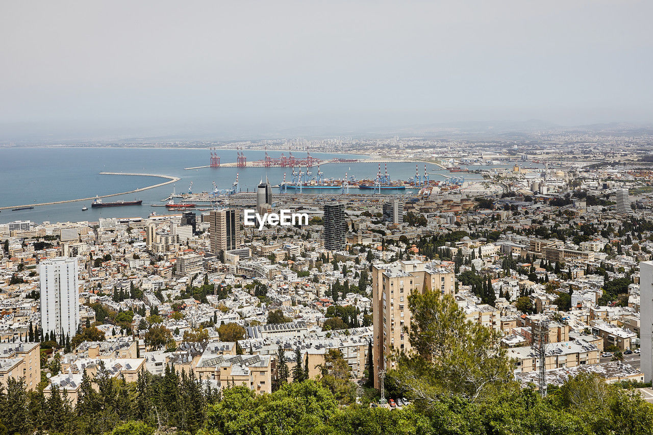 high angle view of cityscape by sea against clear sky