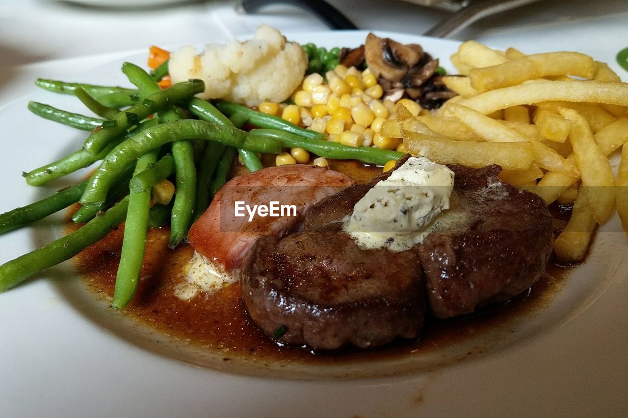 CLOSE-UP OF MEAT AND VEGETABLES IN PLATE