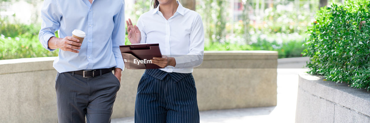 MIDSECTION OF MAN HOLDING WOMAN STANDING BY TEXT