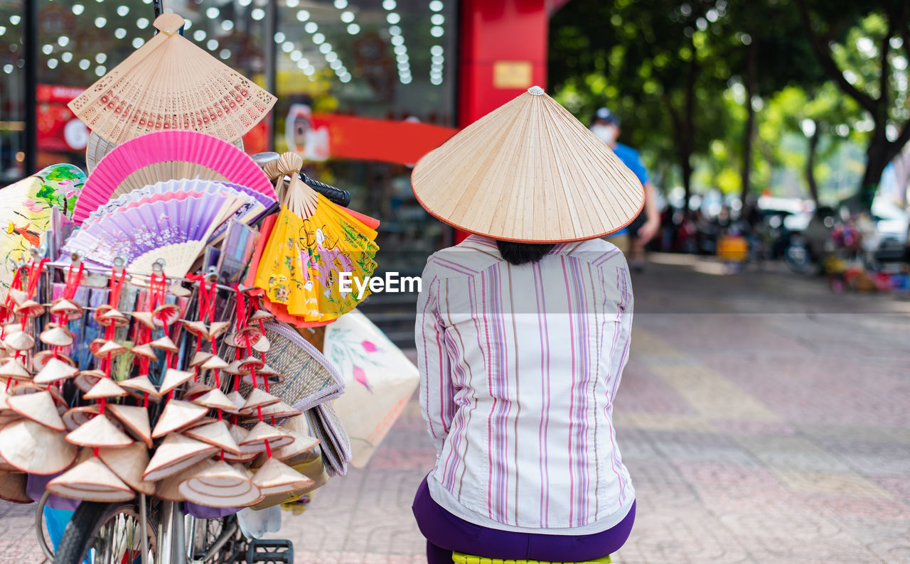 rear view of woman wearing hat standing in market