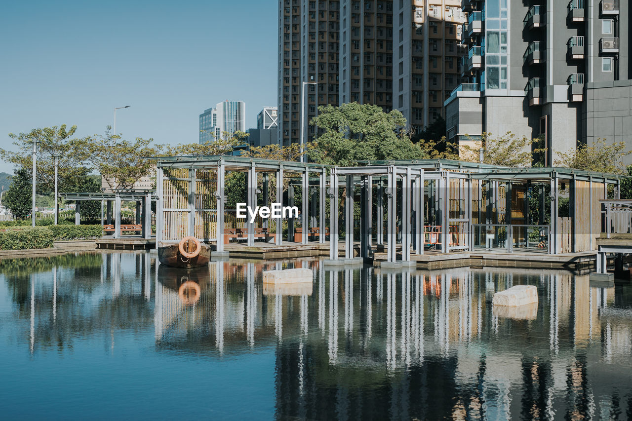 REFLECTION OF BUILDINGS IN LAKE AGAINST SKY