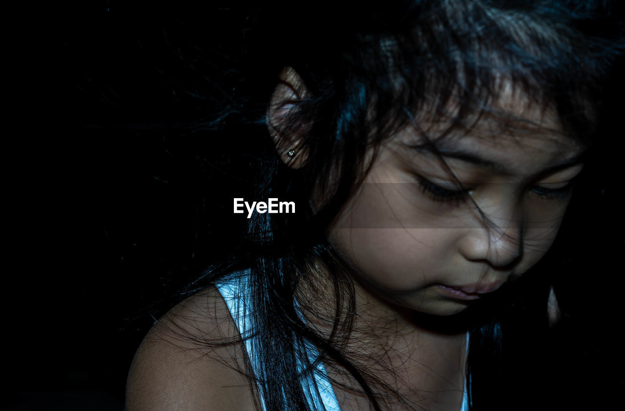 CLOSE-UP PORTRAIT OF A GIRL IN DARK