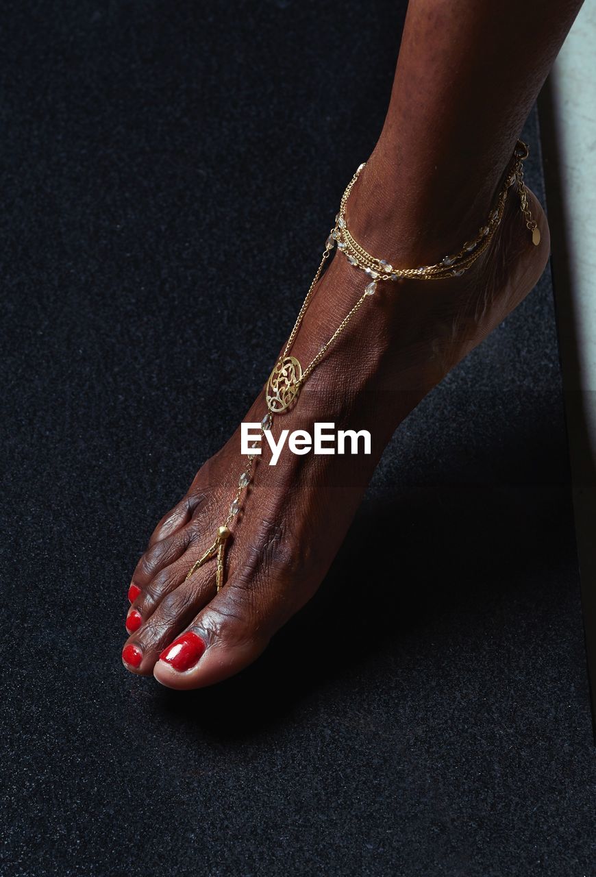 Low section of woman wearing anklet