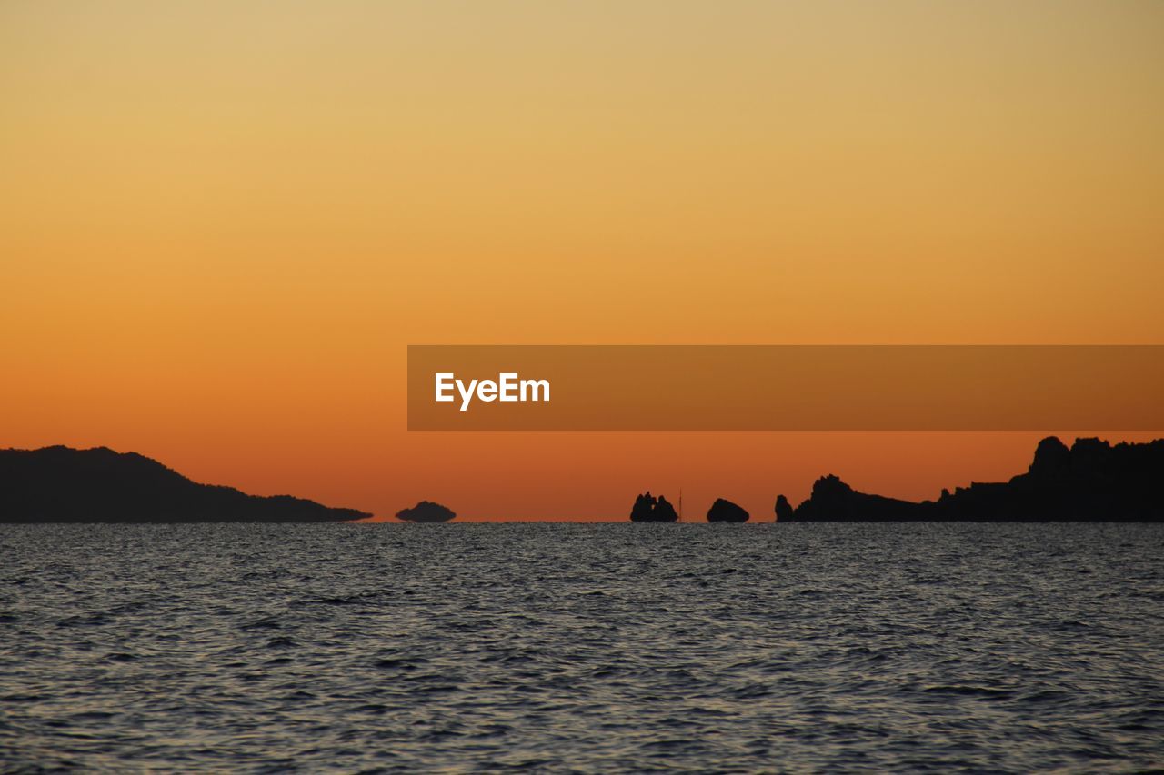 Scenic view of sea against orange sky