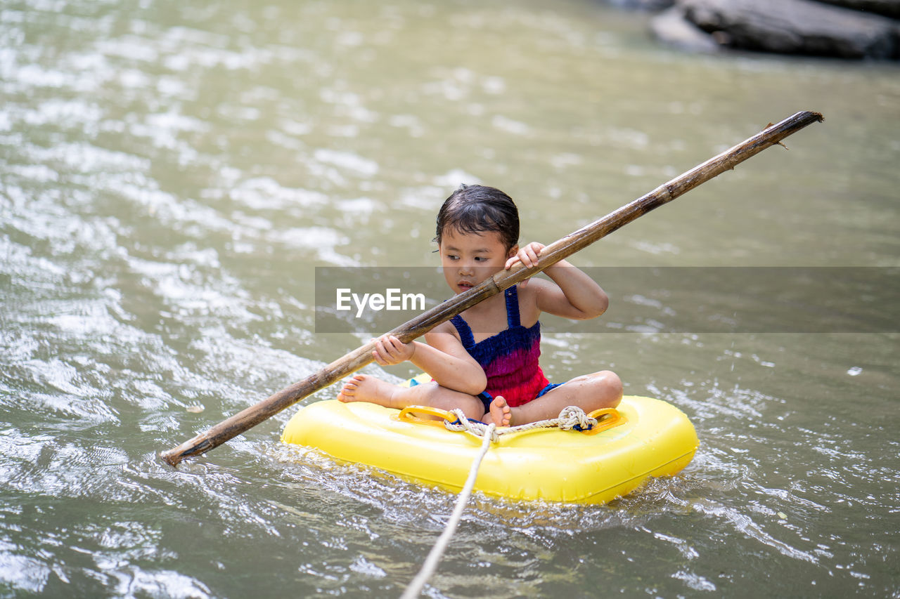 Active little girl playing at mountain stream