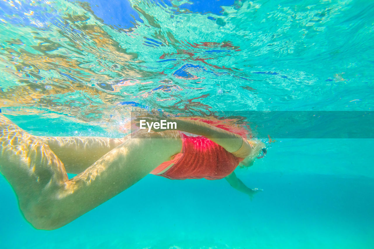 Low angle view of young woman swimming in sea