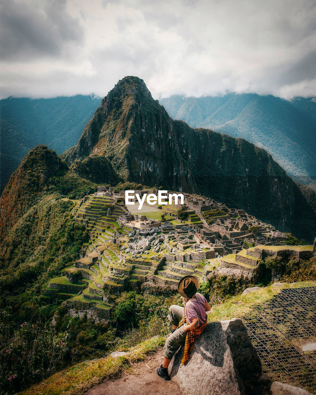 Rear view of woman sitting on rock