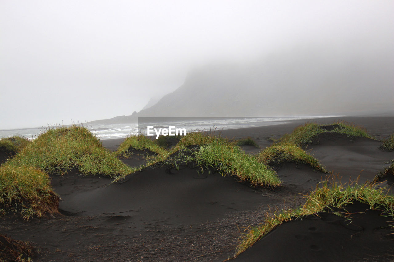 SCENIC VIEW OF SEA BY MOUNTAIN AGAINST SKY