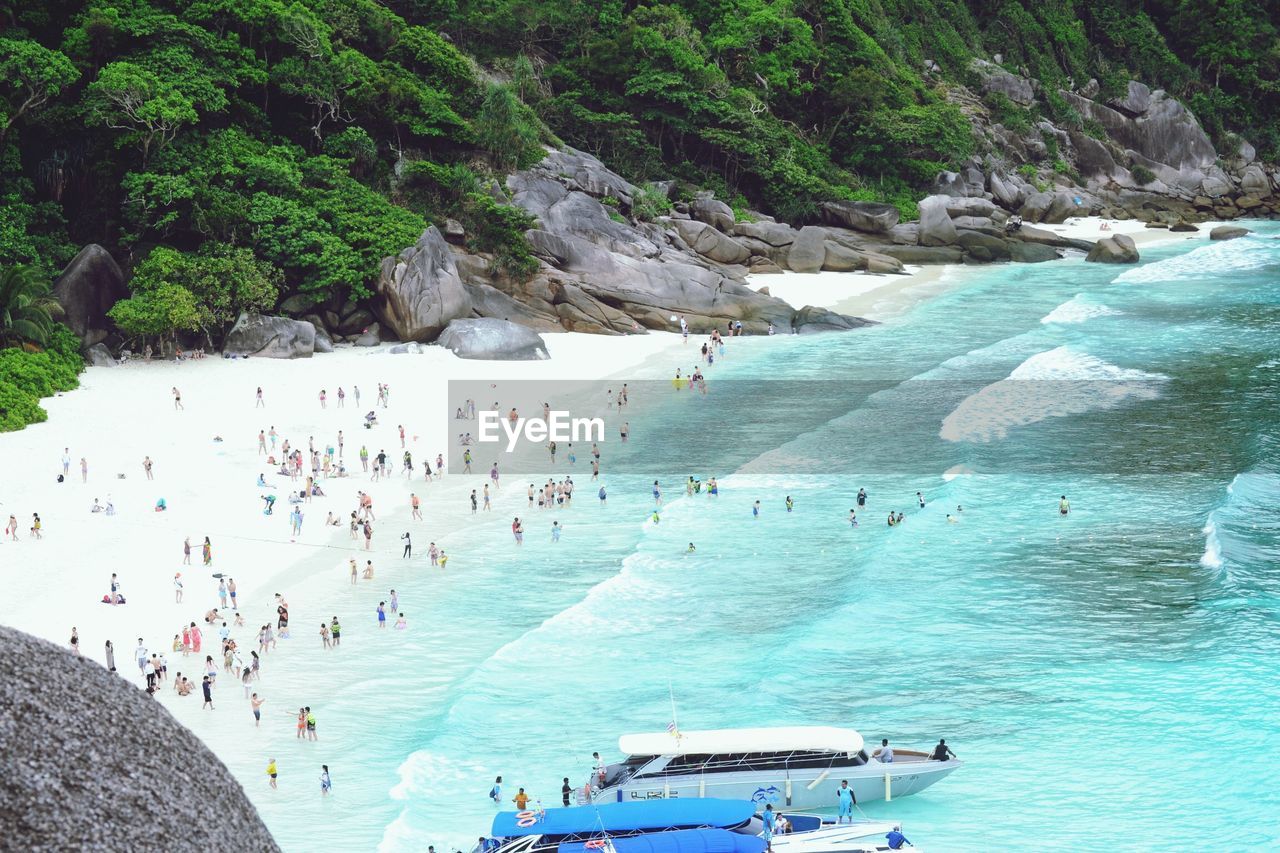 High angle view of people enjoying in sea against mountain