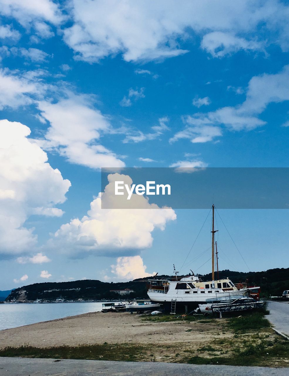 Sailboats moored at beach against sky