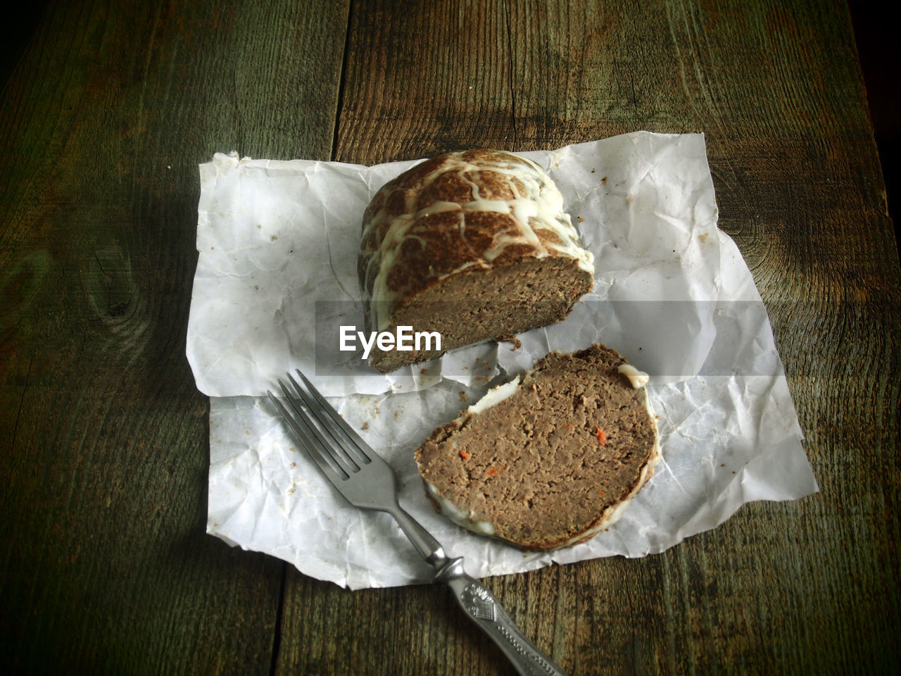 High angle view of bread with slice and fork on table