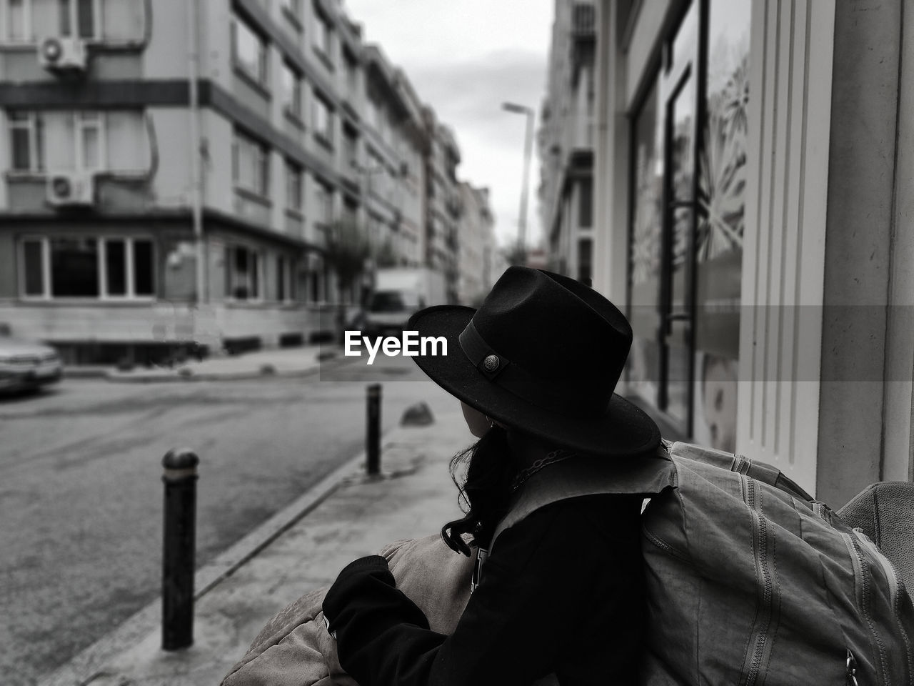 side view of woman wearing hat standing on street in city