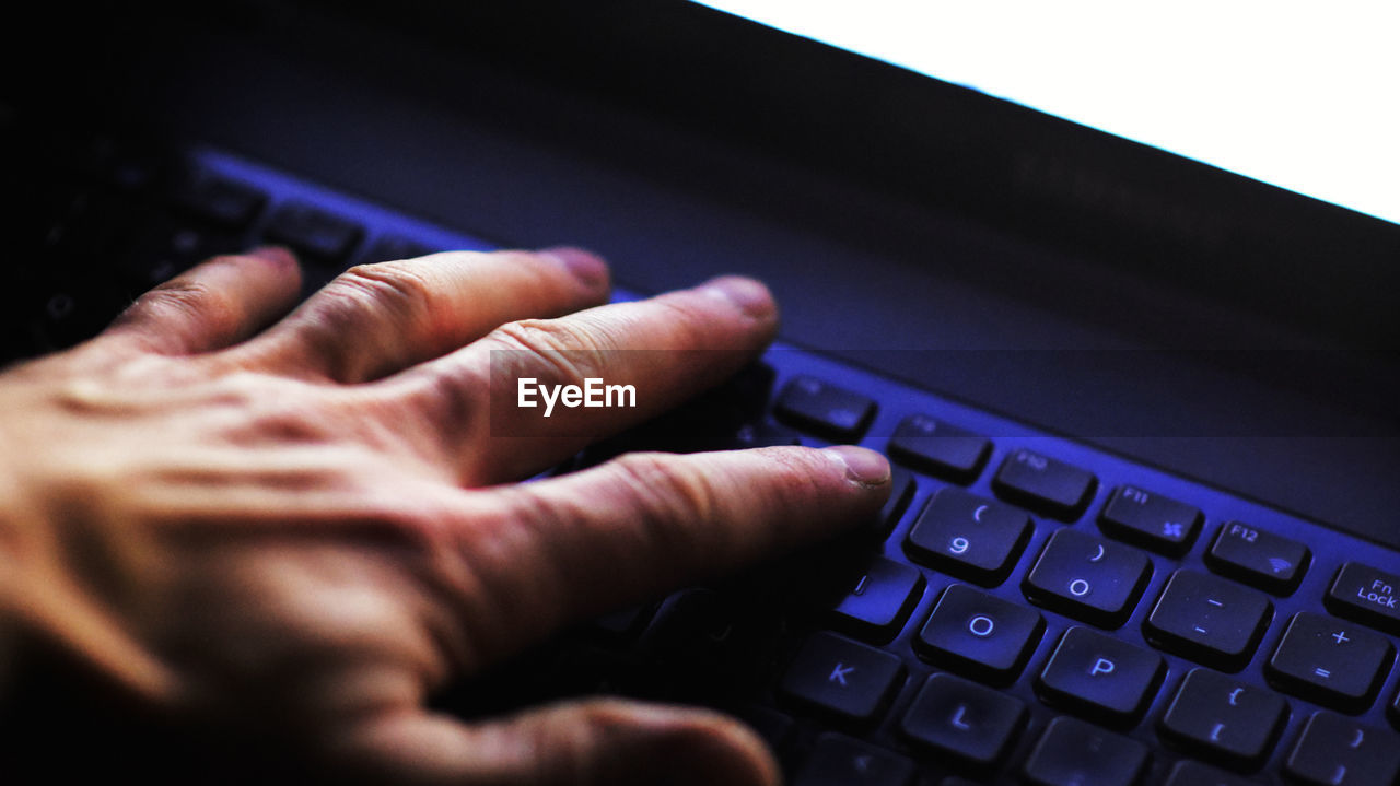 Close-up of hand using laptop