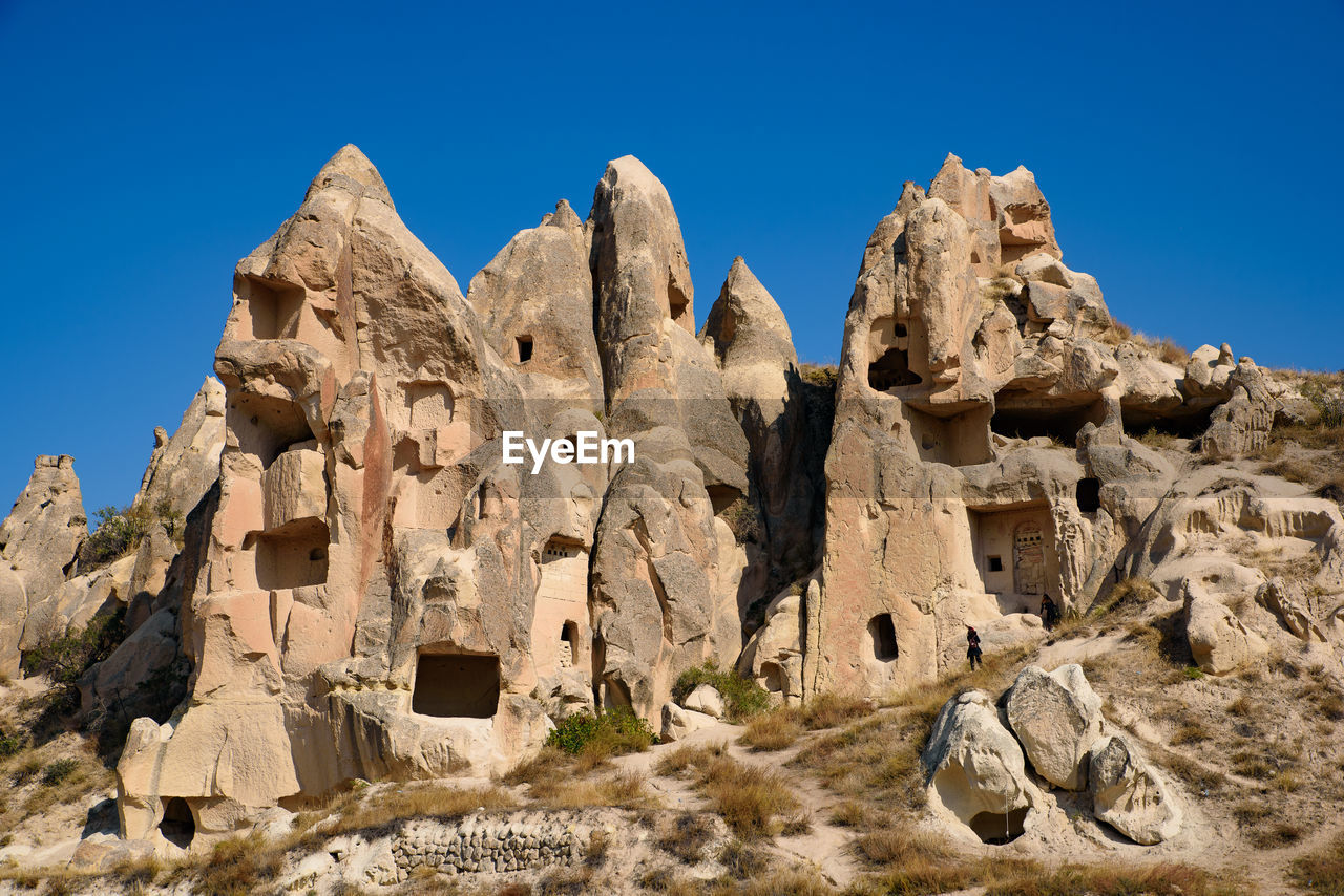 Rock formations against clear blue sky