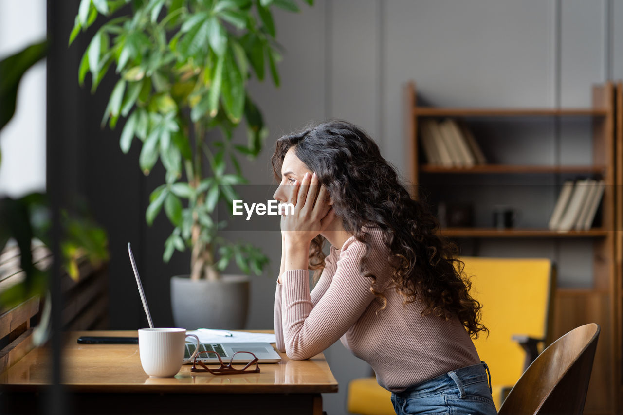 Bored girl tired of learning online sit look at laptop. lazy female freelancer frustrated about task