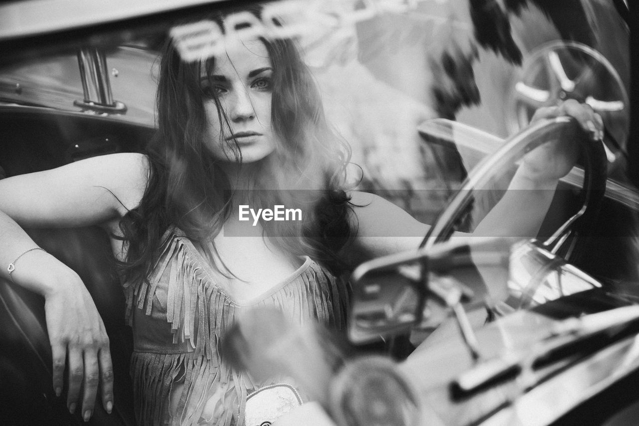 Portrait of beautiful woman sitting in car