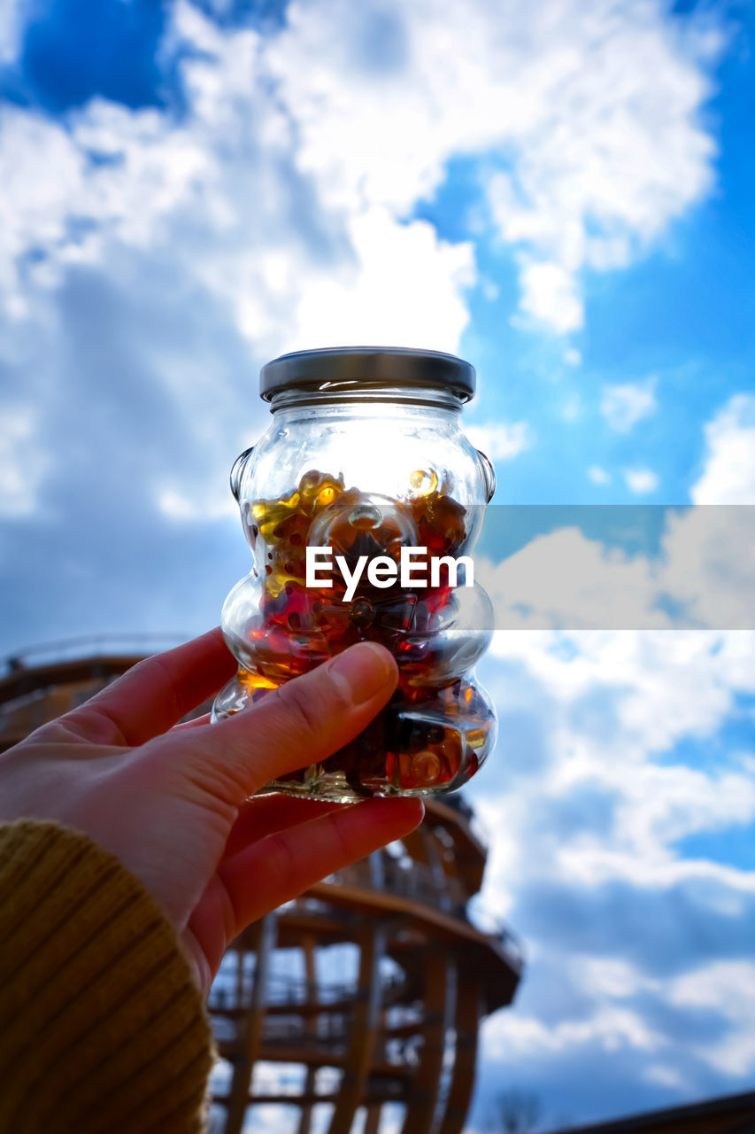 MIDSECTION OF PERSON HOLDING GLASS OF SKY