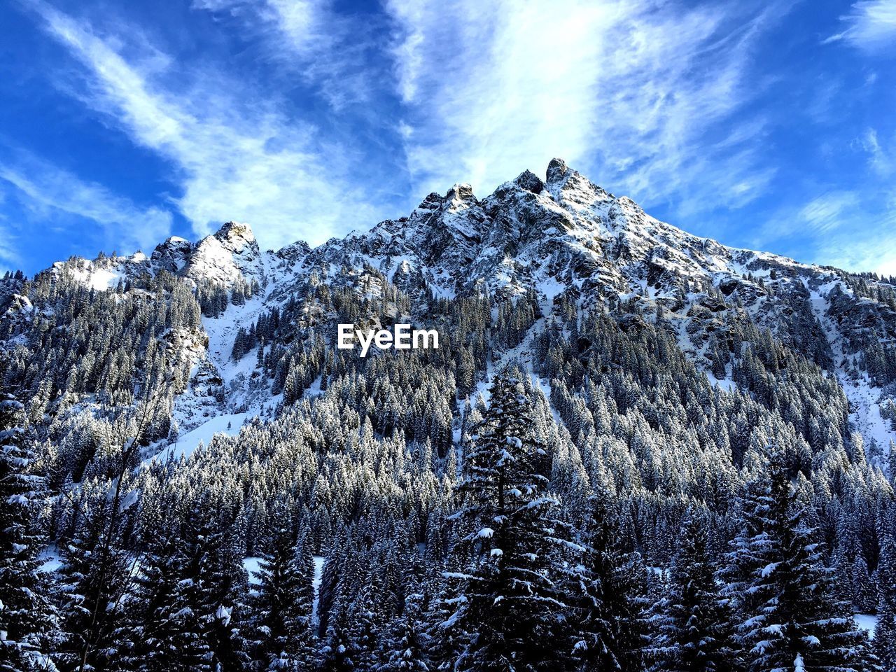 Low angle view of snow covered mountain against sky