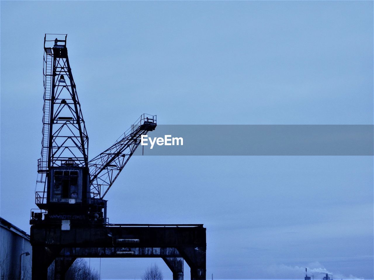 Low angle view of crane at construction site against sky