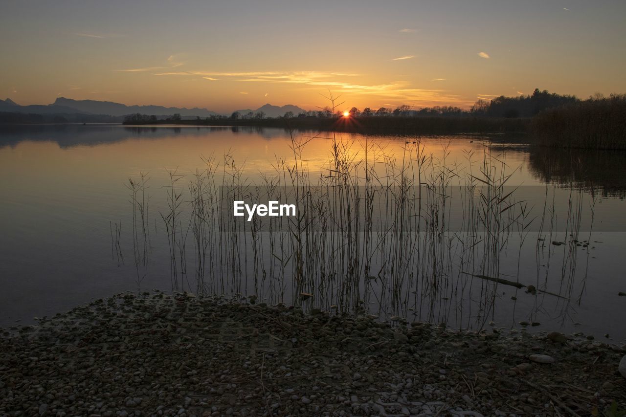 SCENIC VIEW OF LAKE AT SUNSET