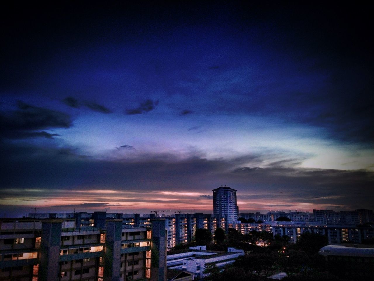 VIEW OF CITYSCAPE AGAINST CLOUDY SKY