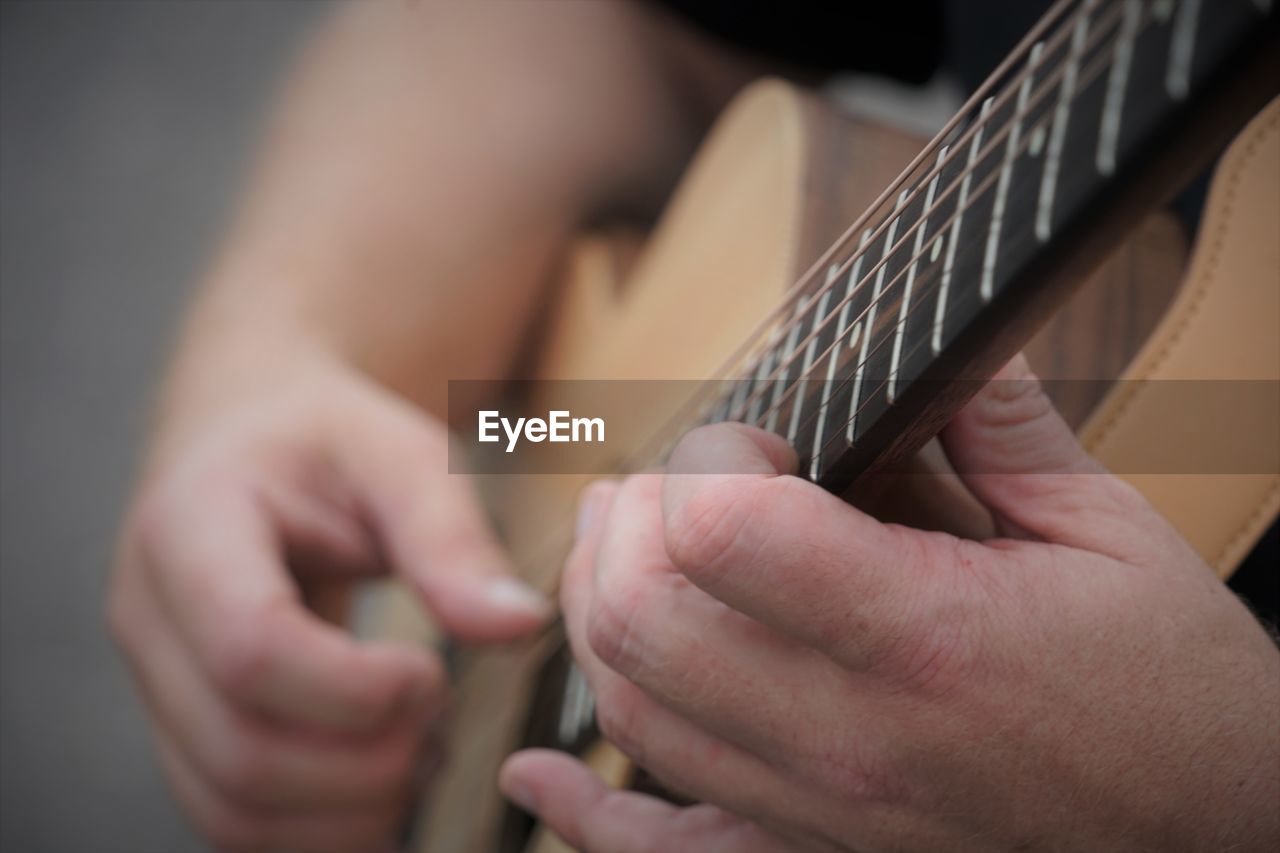 musical instrument, hand, string instrument, music, close-up, musical equipment, arts culture and entertainment, guitar, musician, plucking an instrument, one person, skill, adult, indoors, selective focus, acoustic guitar, holding, plucked string instruments, bass guitar, string, performance, musical instrument string, finger, creativity