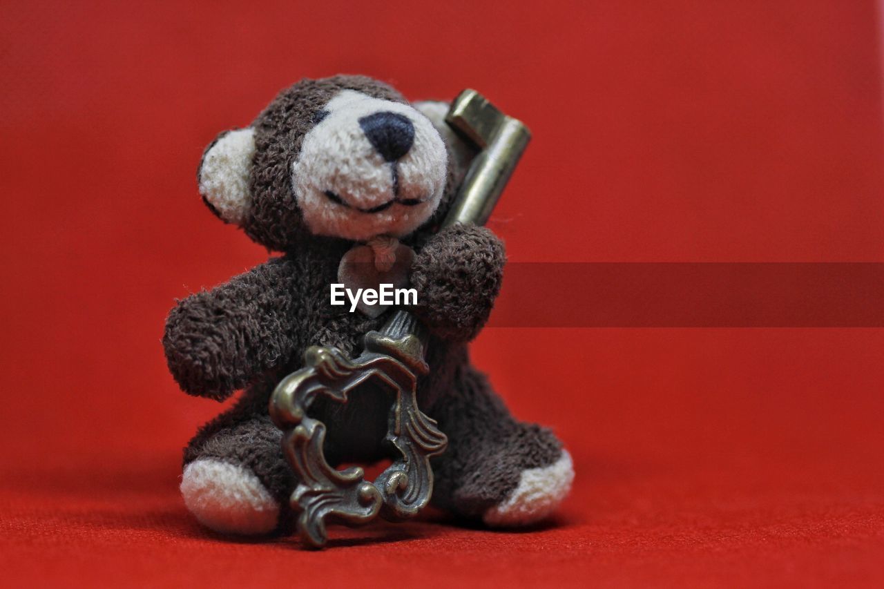 Close-up of stuffed toy against red background