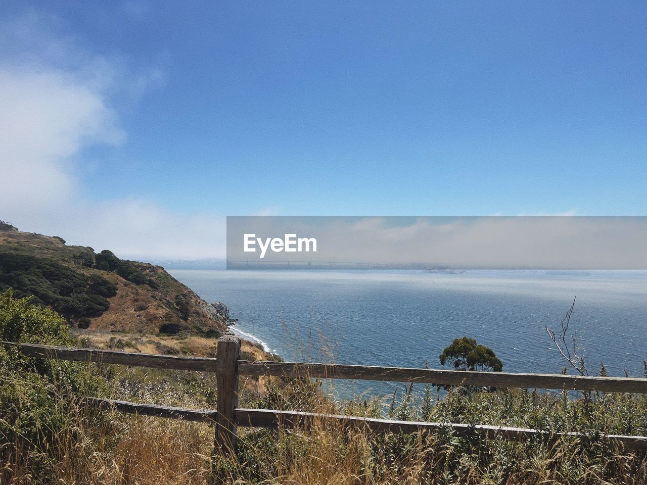 sky, water, sea, coast, cloud, scenics - nature, nature, land, fence, beauty in nature, mountain, tranquil scene, tranquility, ocean, no people, environment, beach, day, horizon, railing, landscape, plant, horizon over water, shore, outdoors, travel destinations, travel, non-urban scene, vacation, tourism, blue, security, body of water, reservoir, architecture, coastline, protection, idyllic, bay, cliff