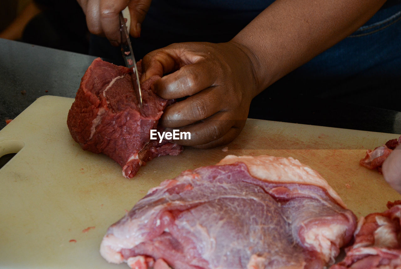 cropped image of man cutting meat