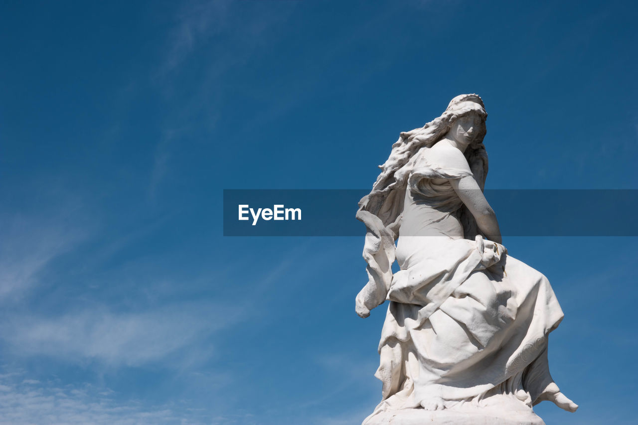 Low angle view of statue against blue sky